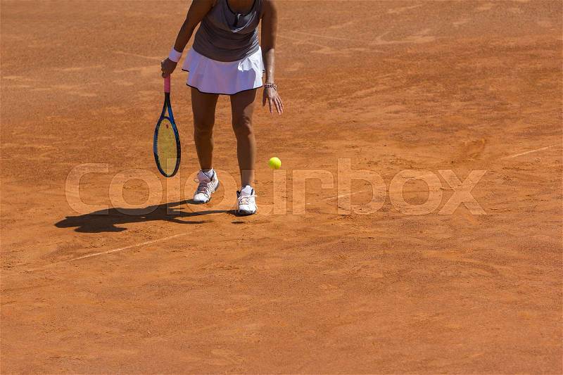 A woman tennis player preparing to serve in tennis cort, stock photo
