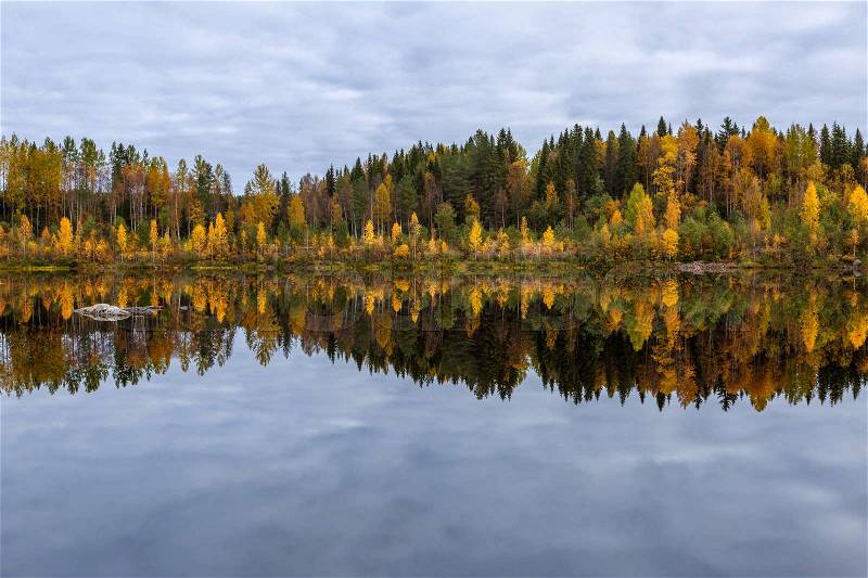 Beautiful autumn landscape with forest, lake and reflection, Finland, stock photo