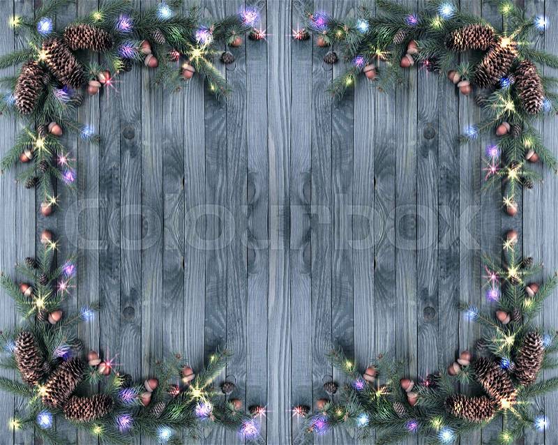 Christmas banner with fir tree frame, illumination, glowing stars, pine cones and acorns on wooden board background. Winter holidays concept. , stock photo