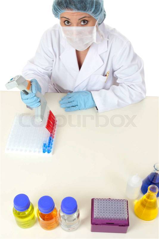 Laboratory worker sitting at desk doing scientific research or testing, stock photo