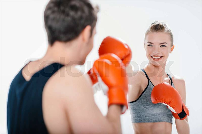 Beautiful young girl boxing with trainer isolated on white, stock photo