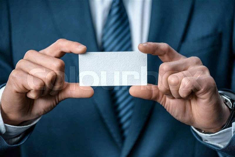Cropped shot of businessman in suit showing business card in hands, stock photo