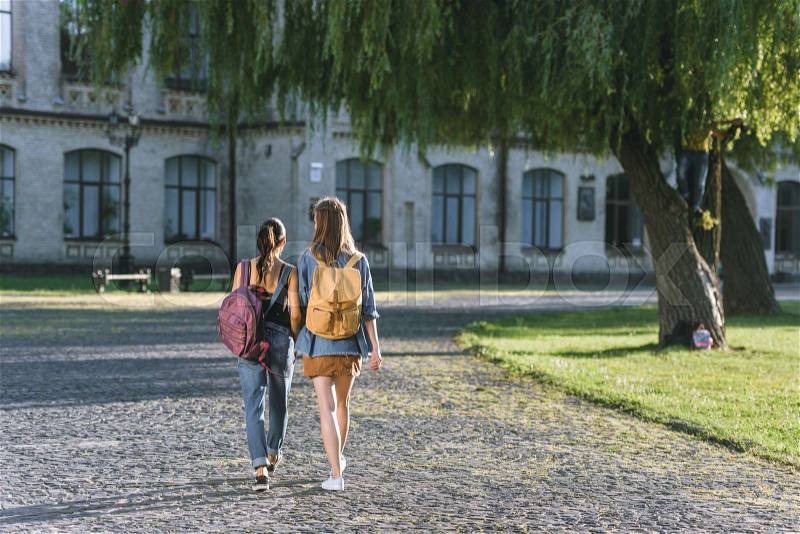 Back view of girls walking in university park, stock photo