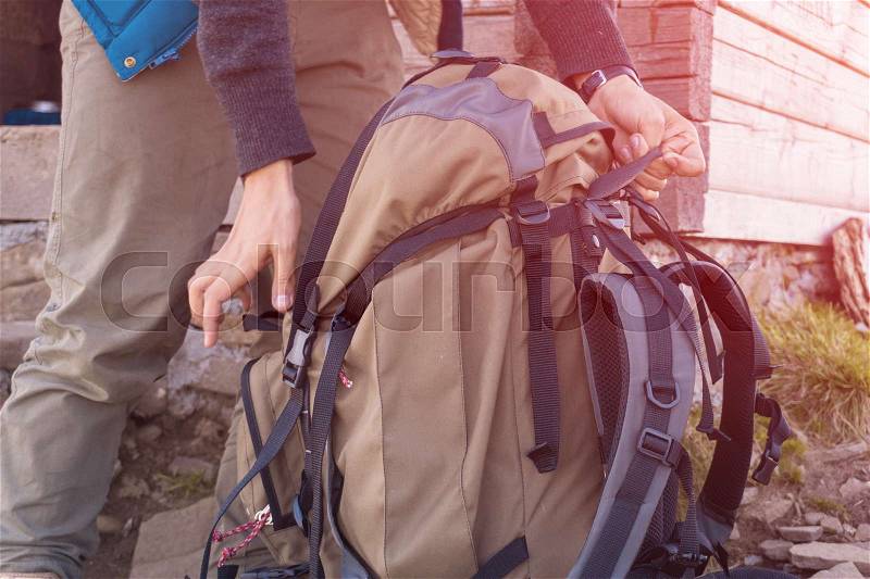 Man lifts travel backpack In the mountains. close-up, stock photo
