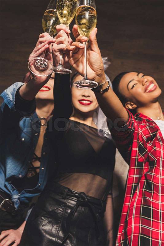 Multicultural women with glasses of champagne at hen party, stock photo
