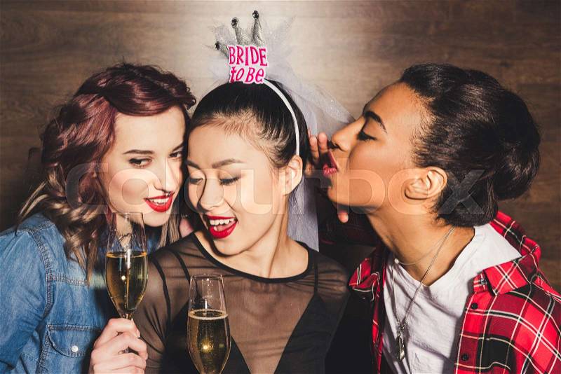 Multicultural women with glasses of champagne at hen party, stock photo