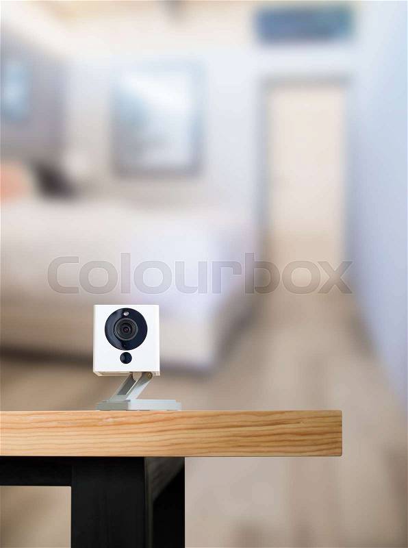 Security camera on Wood table. IP Camera.View of a modern living room background, stock photo