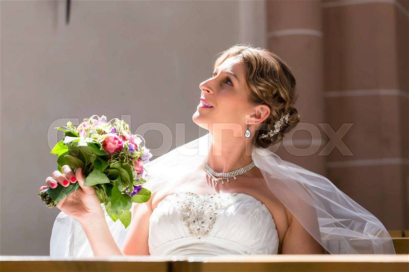 Bride at wedding in church with flower bouquet waiting for the marriage, stock photo