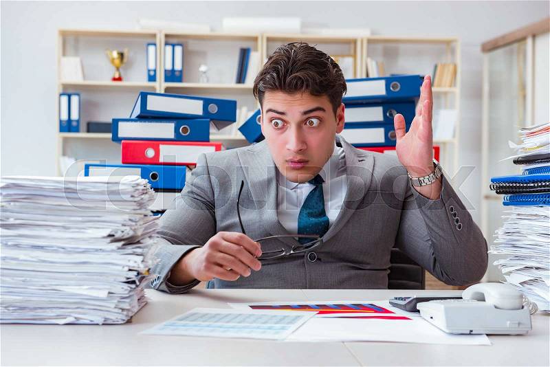 Businessman busy with much paperwork, stock photo