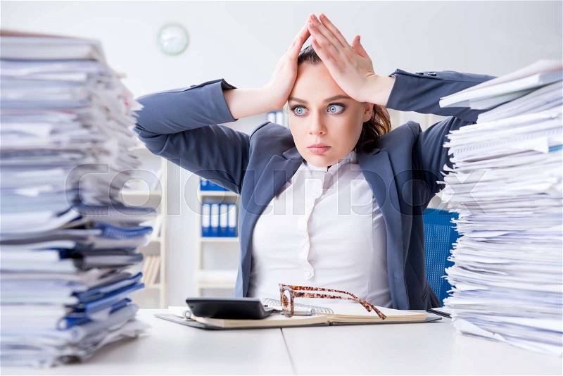 Tired businesswoman with paperwork workload, stock photo
