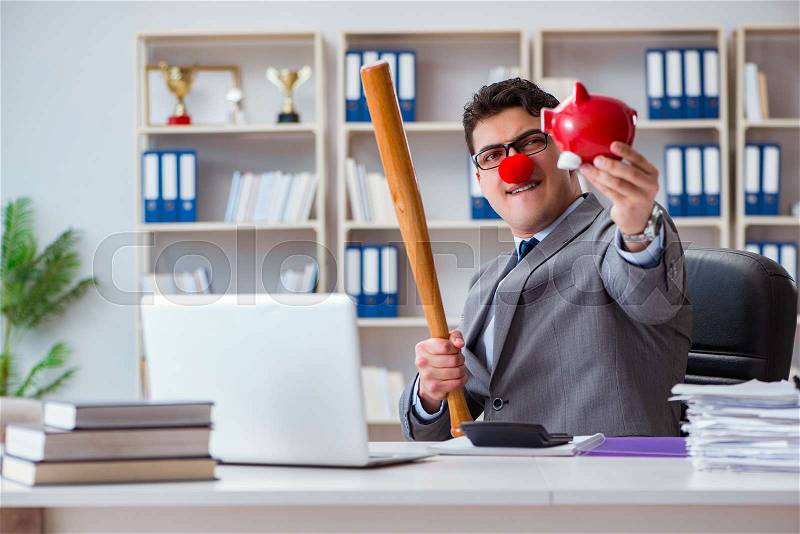 Clown businessman with a baseball bat and a piggy bank, stock photo