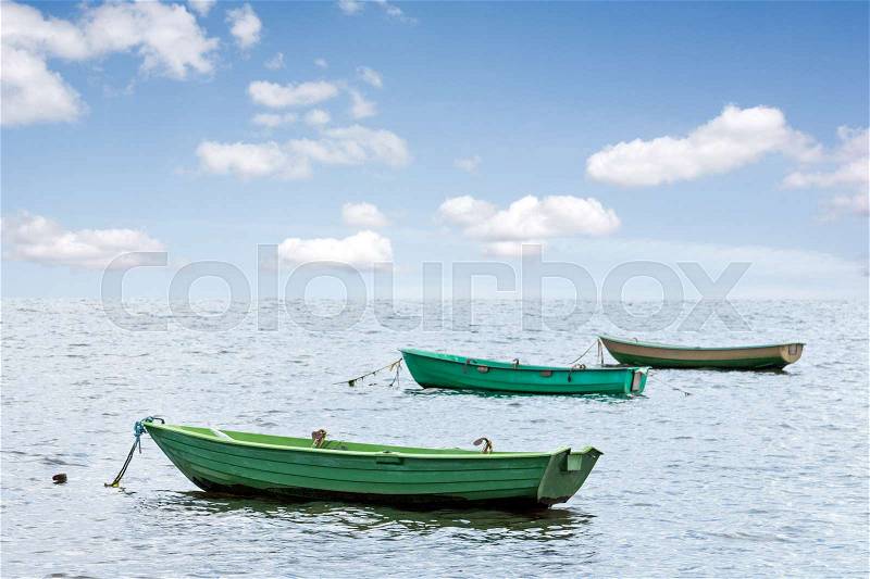 Three wooden boats floating out to sea, stock photo