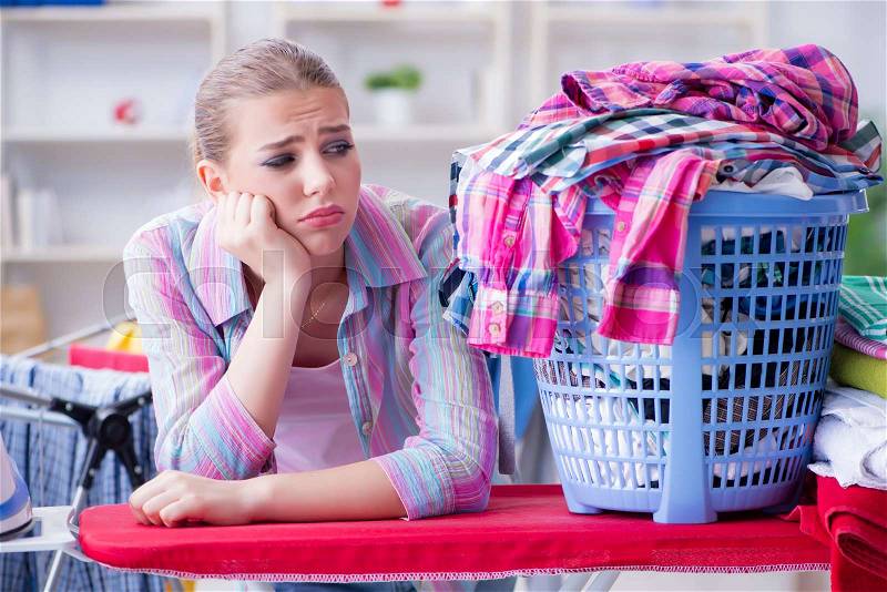 Tired depressed housewife doing laundry, stock photo