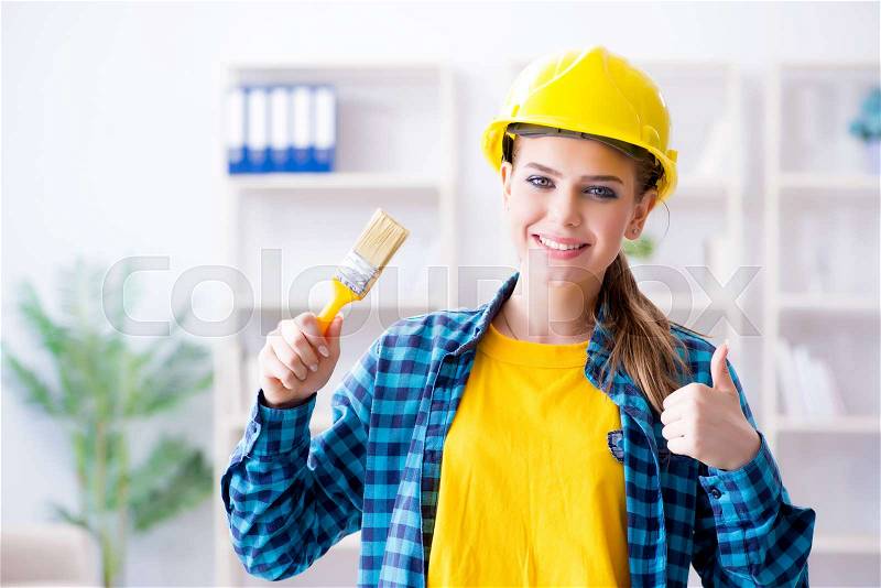 Woman painter with paintbrush in workshop, stock photo