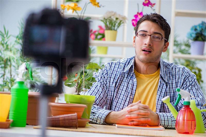 Man florist gardener vlogger blogger shooting video on camera, stock photo