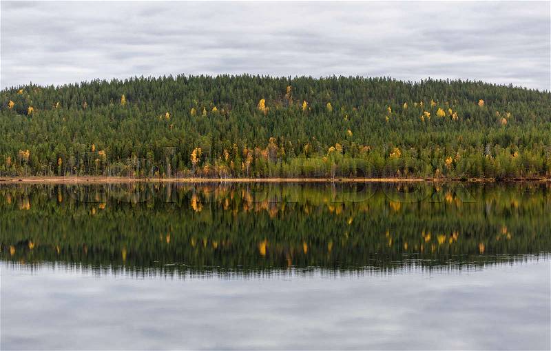 Autumn landscape with forest, lake and reflection, Finland, stock photo