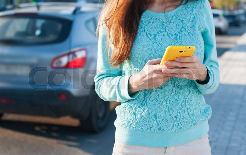 Woman with phone dialing message with cars, stock photo