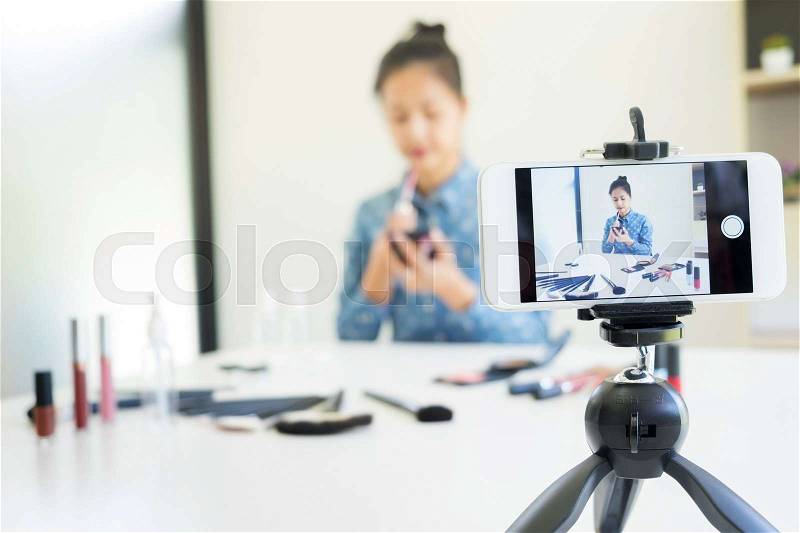 Woman present beauty cosmetic product and broadcast live video to social network by internet at home, beauty blogger concept , stock photo