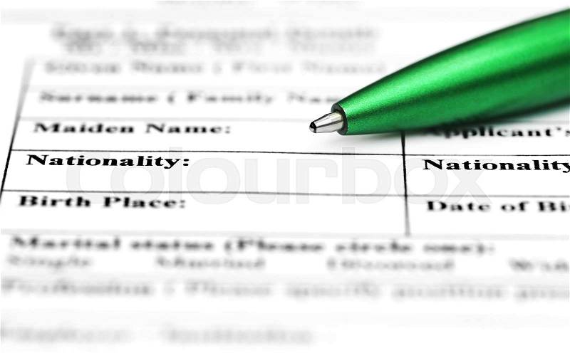 Visa application form filling with green ballpoint, stock photo