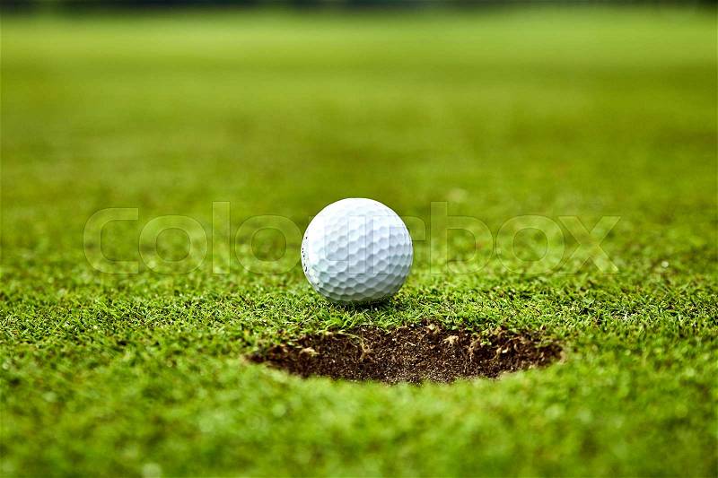 Golf ball on the green. golf ball on lip of cup, stock photo