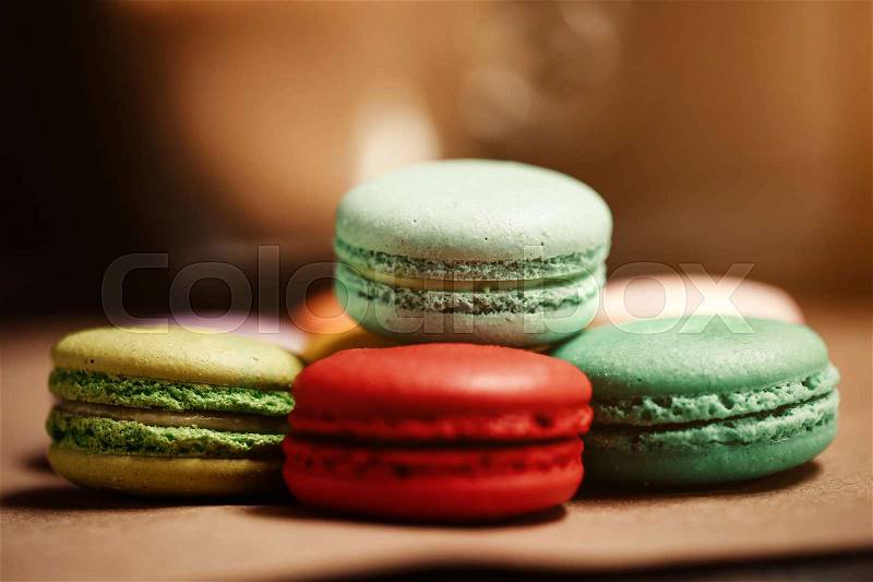 Colorful macarons cake. Closeup macaroons on color white isolated background. in coffee shop vintage color. Coffee grinder and on wooden table with flare. Retro style. Food natural background, stock photo