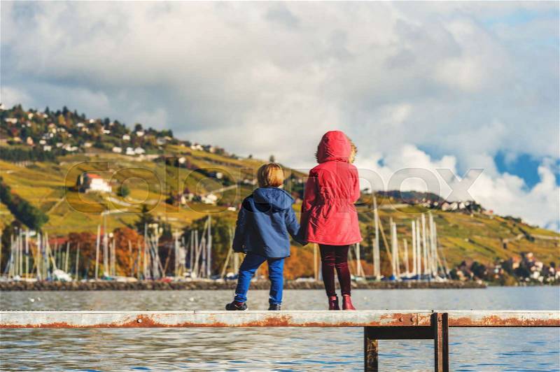 Two kids admiring amazing view of Lake Geneva, Switzerland, back view, stock photo