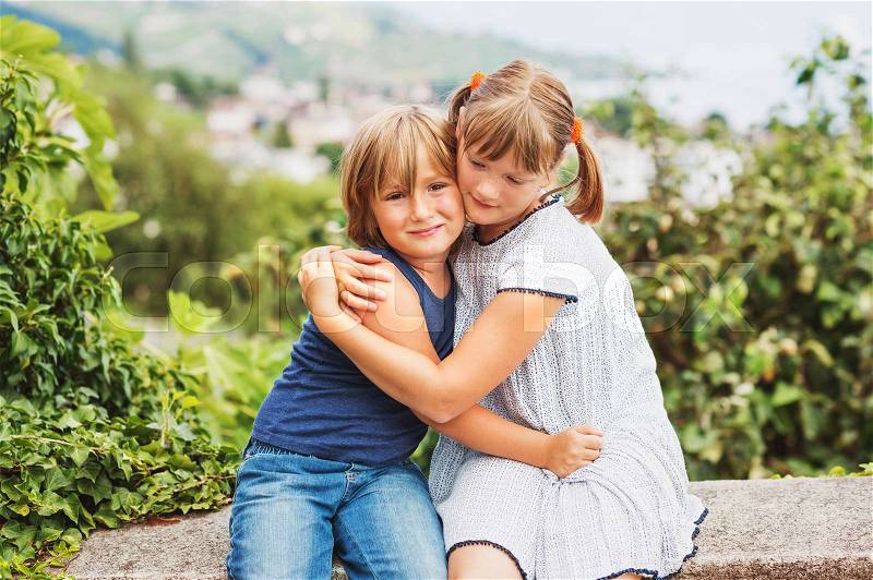 Happy little kids hugging each other, brother and sister playing together, siblings love, stock photo