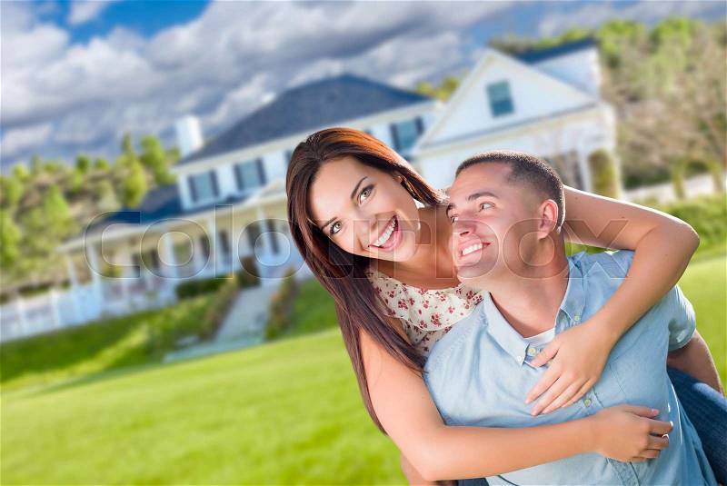 Playful Young Military Couple Outside A Beautiful New Home, stock photo
