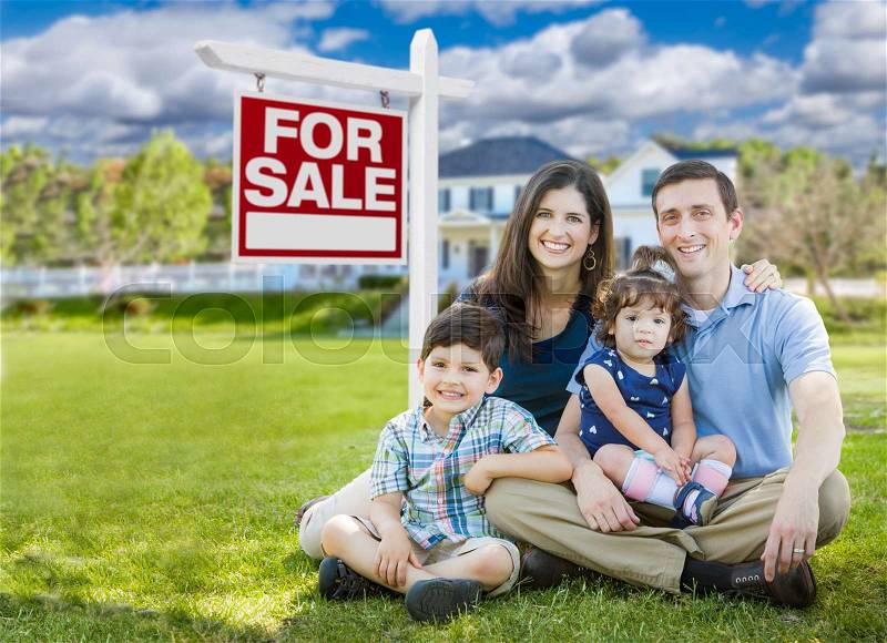 Young Family With Children In Front of Custom Home and For Sale Real Estate Sign, stock photo