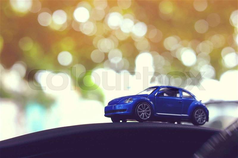 Small vehicle car toy driving travel road trip in nature with beautiful sun light shiny green bokeh background, image used retro vintage tone filter, stock photo