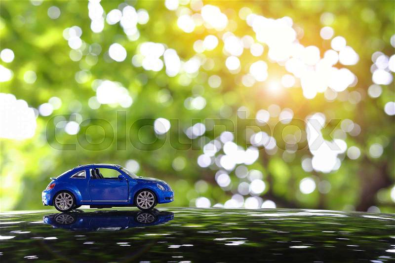 Small vehicle car toy driving travel road trip in nature with beautiful sunlight shiny green bokeh background, image used retro vintage tone filter, stock photo