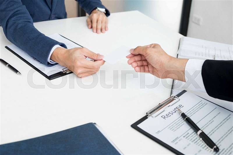 Young businessman at the hiring interview in the office, meeting at office lobby, changing business cards, stock photo