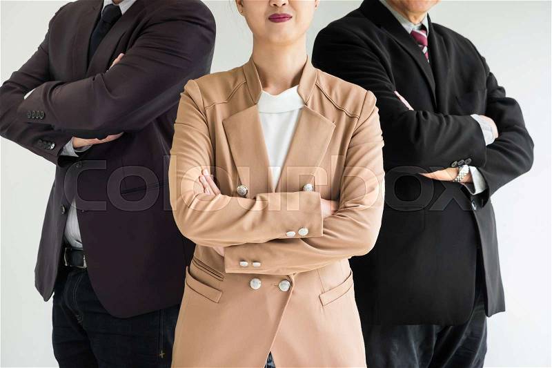 Group of business people with businesswomen leader standing with arms folded on foreground, stock photo