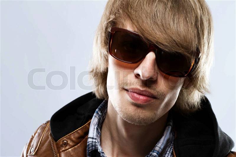 Handsome young man in leather jacket, studio portrait, stock photo