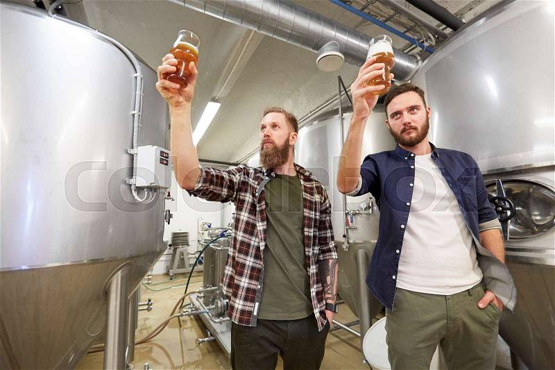 Production, manufacture, business and people concept - men testing non-alcoholic or craft beer at brewery, stock photo