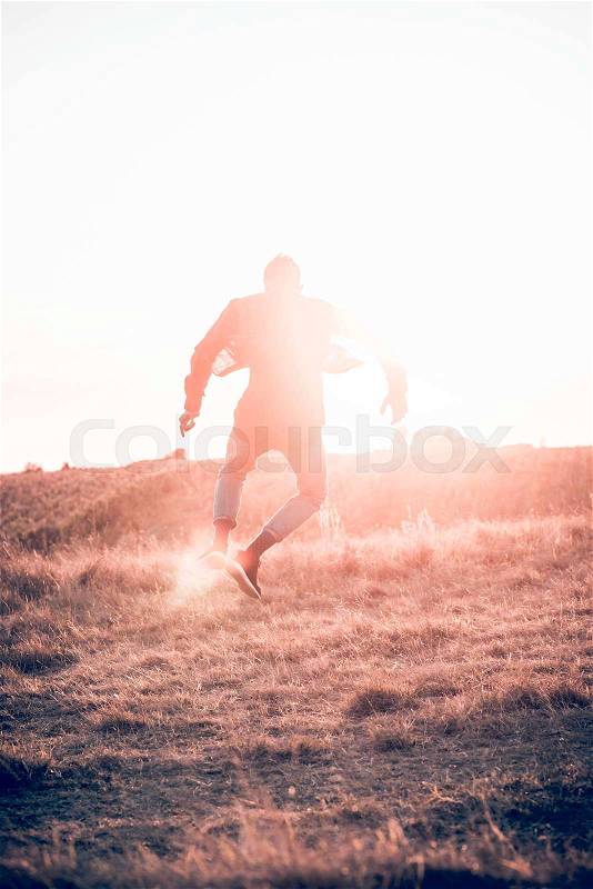 Silhouette of man jumping at field with dusk,blurred motion , stock photo