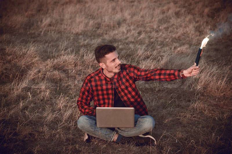 Happy man with the torch and laptop compiuter outdoor , stock photo