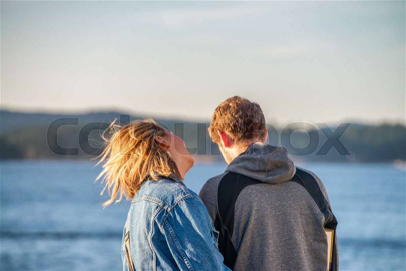 Back view of a young couple enjoying outdoor relax with beautiful landscape, stock photo