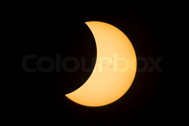 The sun, with a prominent group of sunspots emerges from behind the moon during the total solar eclipse in August, 2017, stock photo