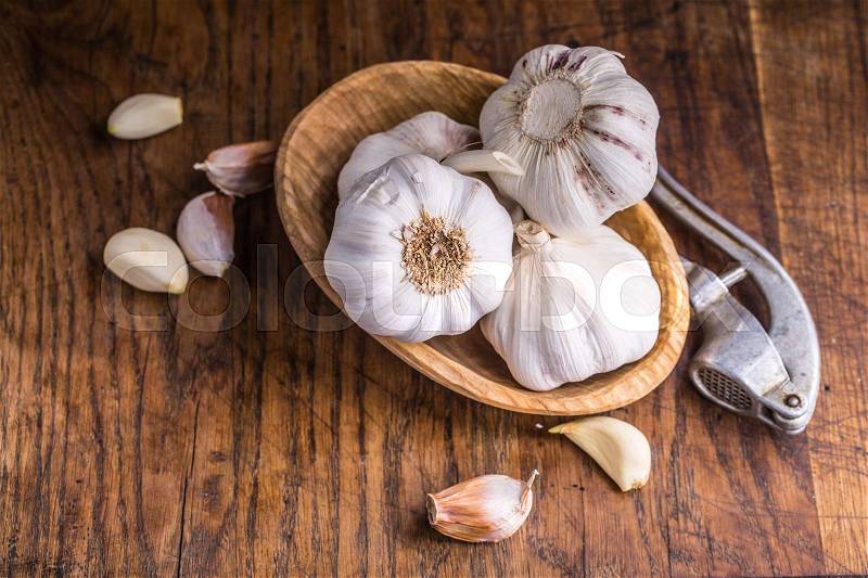Garlic. Garlic Cloves and Garlic Bulb in vintage wooden bowl, stock photo