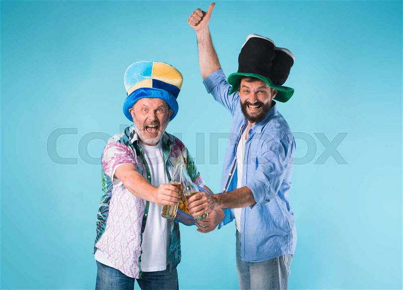 The two emotional football fans over blue background with beer, stock photo