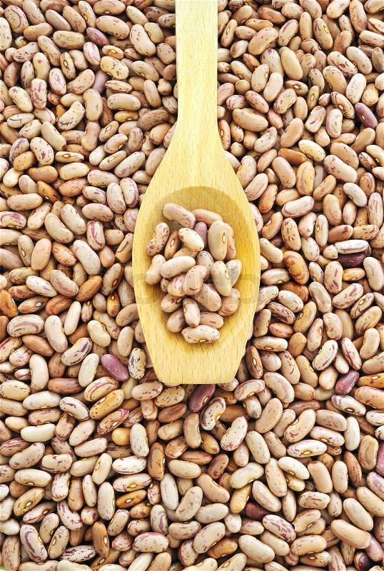Wooden spoon and dried pinto beans, stock photo