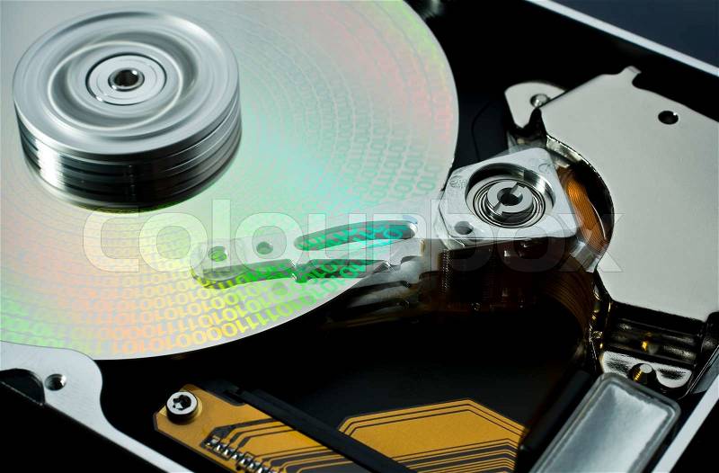 Studio photography of a opened hard disk at work with symbolic data, stock photo