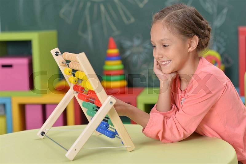 Cute little girl learning to count on abacus, stock photo