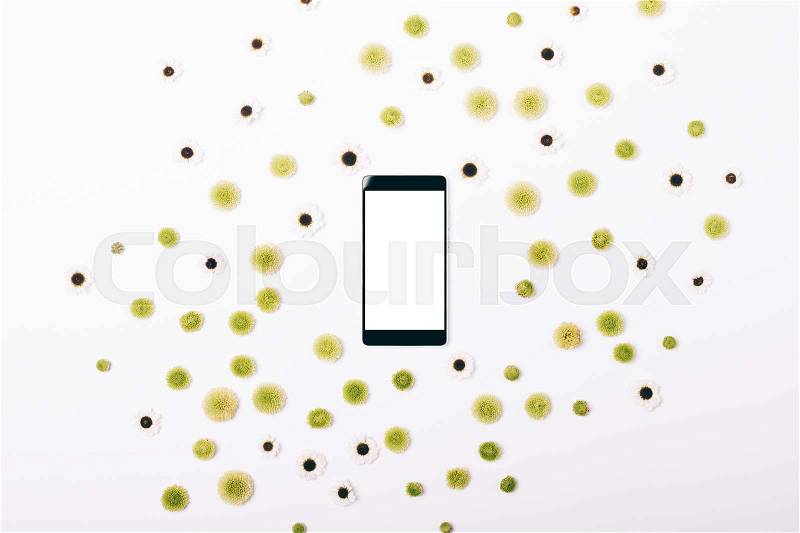 Mobile phone and pattern of flowers on a white table top view, stock photo