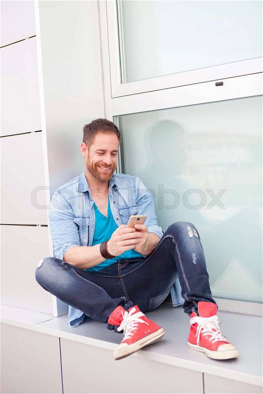Casual guy with a mobile during his rest in the office, stock photo