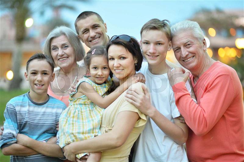 Big happy family standing together and looking at camera on blurred background, stock photo