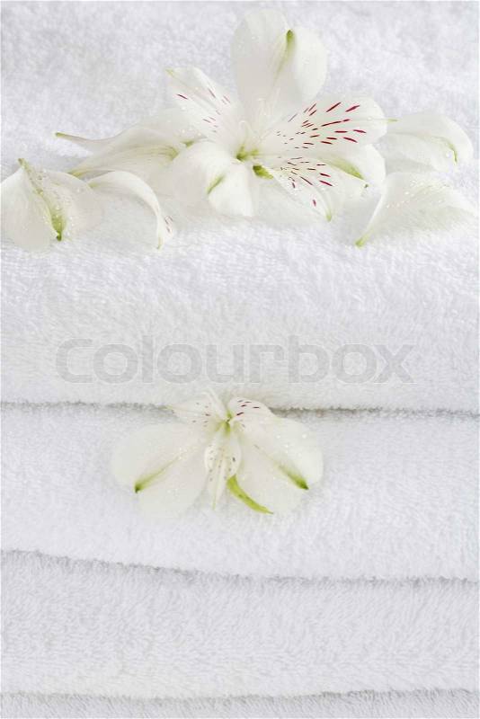 White towels decorated with white flowers for wellness, stock photo