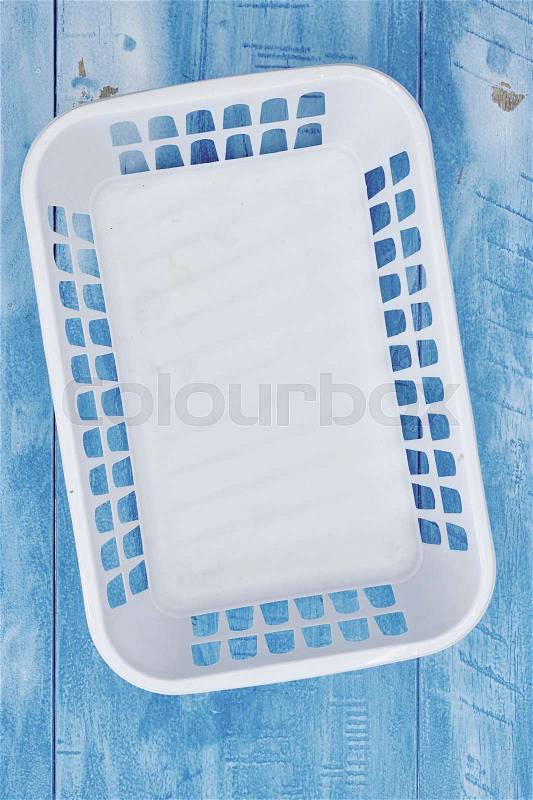 A studio photo of a white plastic storage basket, stock photo