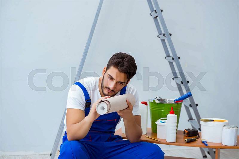Repairman doing renovation repair in the house with paper wallpaper, stock photo